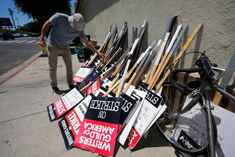 Ein Demonstrant wählt während einer Kundgebung in Los Angeles sein Schild zum Streiken aus. Foto: Mark J. Terrill/AP