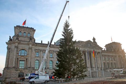 Mit einem Kran wird vor dem Reichstagsgebäude in Berlin der Weihnachtsbaum aufgestellt. Wie die Deutschen das Fest 2020 feiern, entscheidet sich an diesem Mittwoch.   Foto: dpa 
