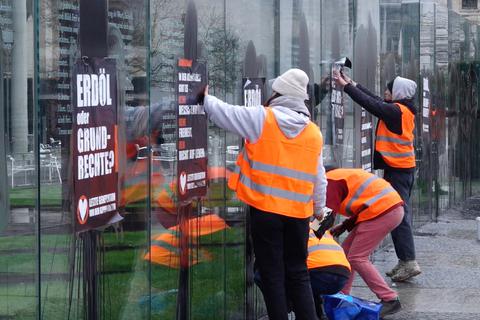 Klimaaktivisten der „Letzten Generation“ beschmieren die gläserne Grundgesetz-Skulptur im Regierungsviertel und kleben Plakate darauf.