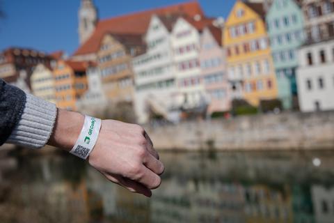 Ein Mann trägt in Tübingen ein Tagesticket-Armband. Die Stadt stellt das Tagesticket auf ein digitales System um. Wer sich an einer der neun Stationen im Stadtgebiet auf Corona testen lässt, bekommt künftig ein Armband mit einem QR-Code, welches nicht weitergegeben werden kann. Foto: dpa