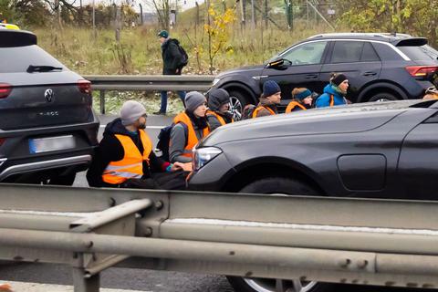 Teilnehmer eines Klimaprotests blockieren auf der A113 kurz vor der Ausfahrt zum Flughafen Berlin Brandenburg (BER) „Willy Brandt“ den Verkehr.