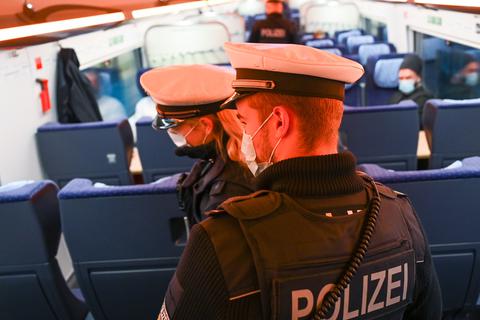 Polizisten kontrollieren die Einhaltung der Corona-Regeln in einem Zug. Symbolbild: dpa