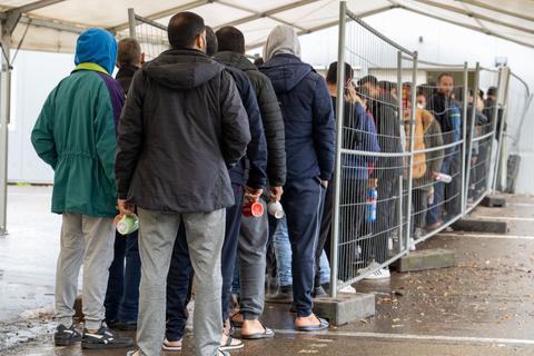 Flüchtlinge warten in einer Aufnahmestelle auf die Essensausgabe. Knapp 218.000 Menschen haben 2022 erstmals in Deutschland Asyl beantragt – so viele wie seit 2016 nicht.