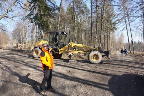 Andreas Friedl von „Hessen Forst Technik“ saniert mit dem Wegegrader die beschädigten Waldwege. Foto: Sven Hollerich