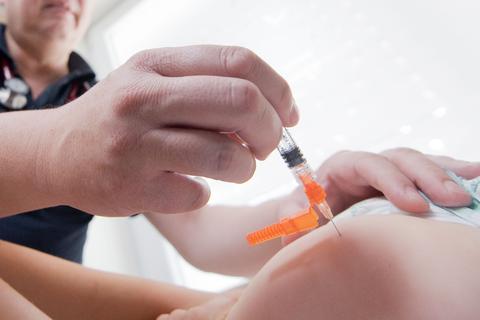 Ein Kinderarzt impft ein einjähriges Kind in den Oberschenkel mit dem Impfstoff Priorix. Foto: dpa