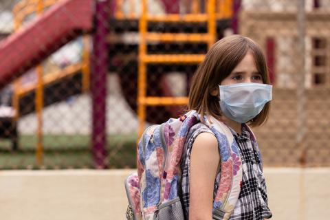 Ein Mädchen trägt auf dem Schulhof eine Maske zum Schutz gegen das Coronavirus. Symbolfoto: falonkoontz - stock.adobe
