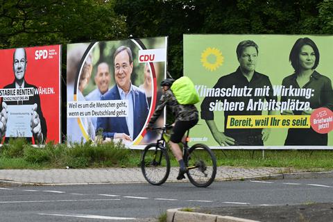 Ein Radfahrer fährt an großen Wahlplakaten in Hessen vorbei. Foto: Arne Dedert/dpa