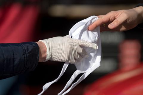 14.04.2020, Sachsen-Anhalt, Halle (Saale): Mitarbeiter der Feuerwehr und der Stadt verteilen auf dem Wochenmarkt in Halle/Saale Mund-Nasen-Schutzmasken. Besucher und Händler des Wochenmarktes müssen ab sofort einen Mundschutz tragen. Foto: Hendrik Schmidt/dpa-Zentralbild/dpa +++ dpa-Bildfunk +++