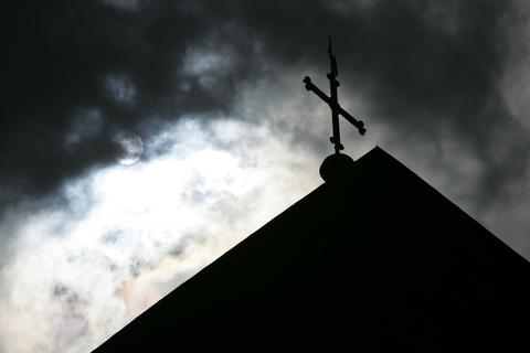 Dunkle Wolken über einem Gotteshaus - immer wieder kommen Missbrauchsfälle in der Kirche zu Tage.  Symbolfoto: dpa