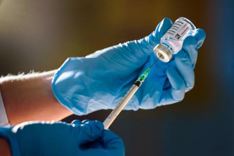 Ein Arzt zieht eine Spritze mit Corona-Impfstoff auf. Foto: Friedrich Stark / epd
