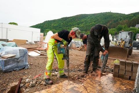 Arbeiter stemmen die Reste eines abgerissenen Wohnhauses in Dernau weg. Foto: dpa