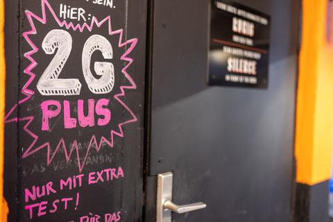 "Hier: 2G PLUS - Nur mit extra Test!" steht auf einem Schild an der geschlossenen Tür einer Bar. Foto: dpa