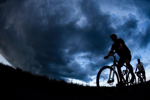 Radfahrer unter dunklem Himmel