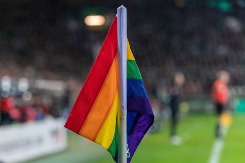 Eine Regenbogenflagge am Rande eines Fußballfeldes.  Foto: nph / Kokenge via www.imago-imag