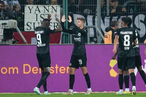 Frankfurts Randal Kolo Muani (l-r) und Torschütze Jesper Lindström jubeln nach dem Treffer zum 3:0. Rechts Frankfurts Djibril Sow. 