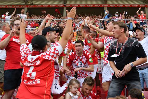 Spieler von Mainz feiern den Sieg gegen RB Leipzig mit den Fans auf der Tribüne. Foto: dpa