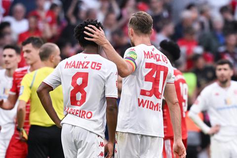 Die Mainz-05-Spieler Leandro Barreiro (l) und Silvan Widmer von Mainz stehen nach dem Spiel in München auf dem Platz. 