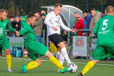Allein gegen drei Gegenspieler: Manderbachs Torschütze Paul Moos (im weißen Trikot) wird von den Eibachern Daniel Lotz, Nico Voss und Nico Sonnenberg umringt. © Jonathan Ortmann