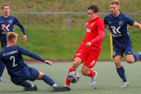 Justin Jordanek im roten Trikot des FC Cleeberg) sieht sich von den Eschenburgern (v. l.) Jan Reiprich, Lasse Thamer (vorn) und Benjamin Arnold umzingelt. Jonathan Ortmann