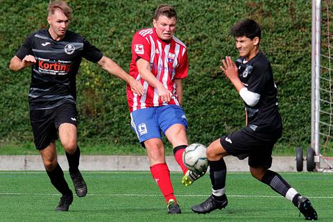 Maximilian Niklos (Mitte) von der Seelbach/Scheld zieht ab, während der Burger Eray Görgülü sich dem Ball entgegenwirft. Links beobachtet Niklas Kilian die Szene.   Foto: Lorenz Pietzsch 