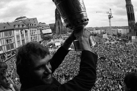 "Schädel-Harry" Karger gewinnt mit der Frankfurter Eintracht nicht nur 1980 den Uefa-Pokal, sondern auch ein Jahr später den DFB-Pokal, den er auf dem Frankfurter Römer in die Höhe reckt.  Foto: imago  