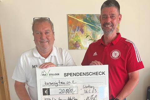 Max Stillger (links) übergibt Kreisfußballwart Marcus Kasteleiner  den Scheck über 20000 Euro für die Vereine.	