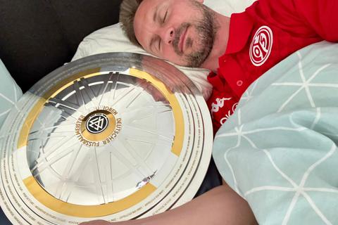 So schläft es sich gut: U19-Meistertrainer Benjamin Hoffmann hat die Trophäe nach der Siegesfeier mit ins Bett genommen. 