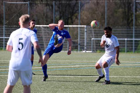 Versbachtals Verteidiger René Anders klärt per Scherenschlag vor dem Michelbacher Leonard Raishtaj.  Foto: Jens Schmidt 