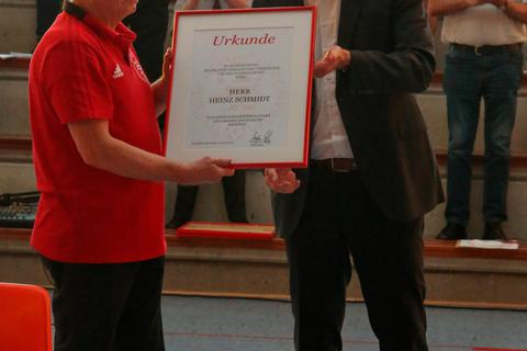 Stefan Reuß (rechts), Präsident des Hessischen Fußball-Verbandes, überreicht Heinz Schmidt die Ernennungsurkunde zum Hinterländer Ehrenkreisfußballwart.  Foto: Jens Kauer 