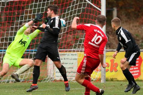 Erst Silberg/Eisenhausens Retter, später vom Platz geflogen. SG Keeper Ole Gaschler pariert einen Schuss von Frohnhausens Stürmer Christian Immel (10) mit dem er in der Nachspielzeit zusammenrasselt und dafür die Rote Karte sieht.  Foto: Jens Schmidt 