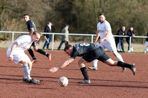 Beim Abstiegskampf auf dem Hartplatz zählen keine Haltungsnoten: Wallaus Spielertrainer Sebastian Meier (links)  und der Dautphetaler David Bernhardt (rechts) knien sich im Zweikampf rein. © Jens Schmidt