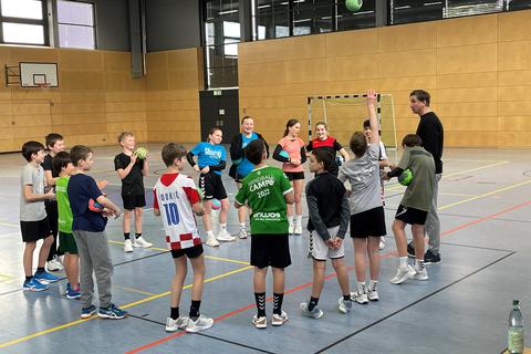 Die Handball-Klasse von Lehrertrainer Volker Michel (r.) im Kreis vor dem Aufwärmtraining. Der frühere Handball-Nationalspieler nimmt sich für seine Schützlinge viel Zeit.