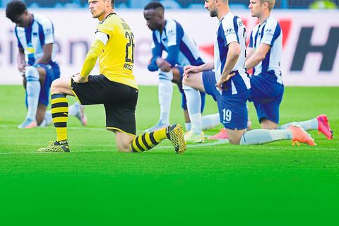 Geste gegen Rassismus: Spieler von Borussia Dortmund und Hertha BSC knien gemeinsam vor dem Anpfiff. Foto: Imago 