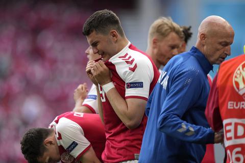 Die dänischen Spieler reagieren, als Christian Eriksen nach einem Zusammenbruch während des Spiels medizinisch behandelt wird. Foto: Martin Meissner/AP Pool/dpa