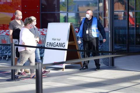 Ein Mitarbeiter reguliert beim Möbelhaus Segmüller in Pulheim den Zugang der Kunden. In Nordrhein-Westfalen können auch Möbelhäuser mit einer Fläche von mehr als 800 Quadratmeter wieder öffnen. Foto: dpa