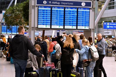 Schon am frühen Montagmorgen stehen Reisende am Flughafen Düsseldorf Schlange. © Roberto Pfeil/dpa