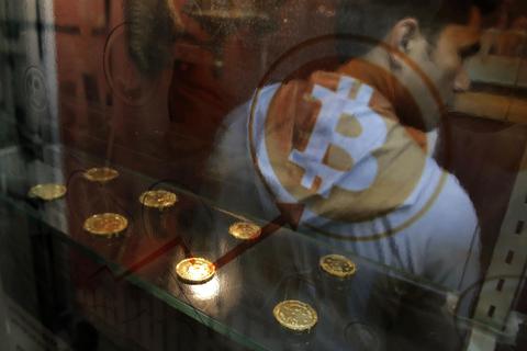 Ein Mann benutzt in Hongkong einen Bitcoin-Automaten. Die Digitalwährung wird nicht von zentralen Instanzen wie Notenbanken oder Regierungen kontrolliert und gewährt bei Überweisungen Anonymität. Foto: dpa