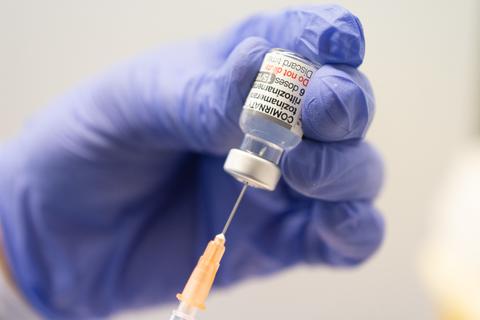 Ein Mitarbeiter zieht im Impfzentrum Mainz eine Spritze mit dem an die Omikron-Variante angepassten Corona-Impfstoff auf. 